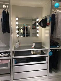 a dressing room with lights on and drawers