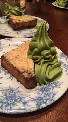 two blue and white plates topped with desserts on top of a wooden table next to each other