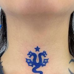 a woman's neck with a blue dragon tattoo on her chest and stars around the neck