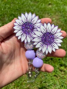 "*Badge reel only*  Badge reel and buddy sets are available herehttps://www.etsy.com/listing/1450782162/purple-sunflower-badge-reel-badge-buddy This hand decorated badge reel is a perfect way to spruce up your work uniform or to give as a gift!  Clip to scrubs, shirt pocket, lanyard and more! --SPECIFICS-- -Decorative face is 2\" on longest side. -I use the highest quality glitter and vinyl, sealed with UV resin for added protection! -I make all badge reels interchangeable so you can change out the faces for holidays, seasons or just everyday wear. (If you prefer to purchase permanently attached please add that in the notes to seller section or just send me a message) *Colors may vary due to the screens brightness and contrast settings.* PLEASE BE AWARE Retractable badge reels are designed Avatar Wardrobe, Purple Sunflower, Scrubs Shirt, Epoxy Tumblers, Glitter Shirt, Work Uniform