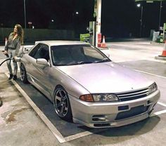 a woman is pumping gas into her car