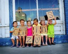 several children holding up signs in front of a window