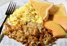 a white plate topped with eggs, toast and other breakfast foods on top of it