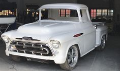 an old white truck parked in a garage