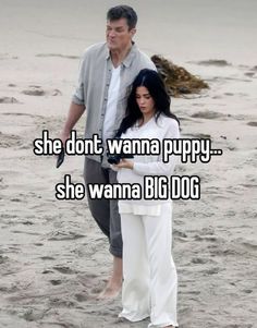 a man and woman standing on top of a beach next to each other with the caption, she don't wanna puppy