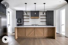 an empty kitchen with wood floors and white walls