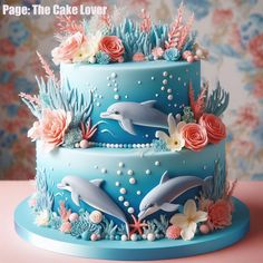 there is a cake decorated with dolphins and corals on the bottom, along with flowers