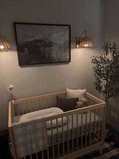 a baby's crib in the corner of a room with two lamps on either side