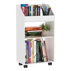 a white book shelf filled with lots of books next to a potted green plant