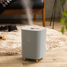 an air purifier is on the floor next to a rug