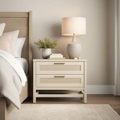 a white bed sitting next to a night stand on top of a hard wood floor