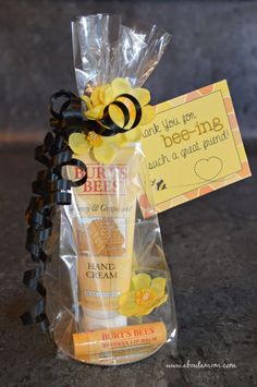 a bag with some yellow flowers on it and a note attached to the package that says bee - ing, such as a good friend