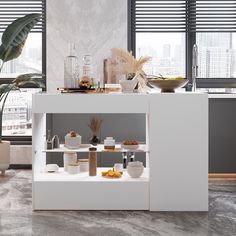 a white counter topped with lots of food next to two large windows covered in blinds