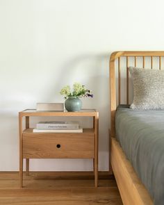 a wooden bed with a nightstand next to it