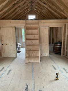 an unfinished room with wooden walls and stairs