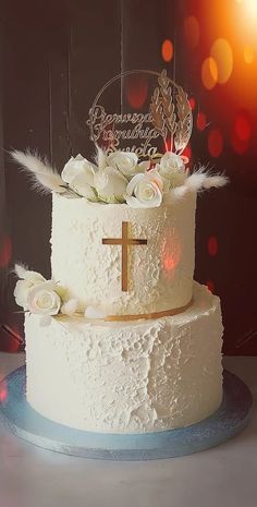 a white cake with flowers and a cross on top