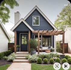 a small blue house with a porch and pergolated area in the front yard