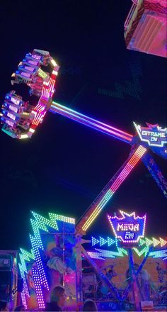 an amusement park at night with lights and rides