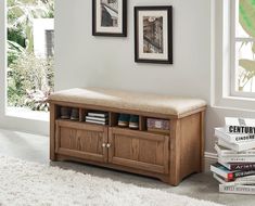 a wooden bench sitting in the middle of a living room next to a pile of books