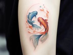 a woman's arm with two goldfish tattoos on it