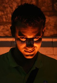 a man looking down at his cell phone in the dark royalty image - free stock photo