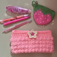 a crocheted purse and other items laid out on a table with pens, scissors, markers, and pencils