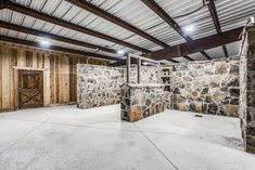 an empty room with stone walls and exposed ceilings