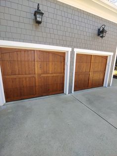 two brown garage doors in front of a brick building