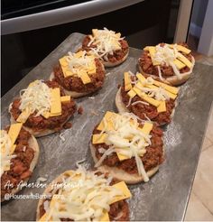 mini pizzas covered in cheese and sauce on top of a baking sheet, ready to go into the oven