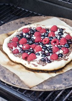 an uncooked pizza with berries and blueberries on it is being cooked in the oven