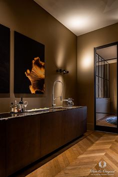 an elegant bathroom with wood flooring and artwork on the wall