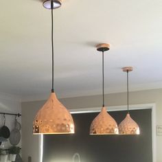 three lights hanging from the ceiling in a kitchen