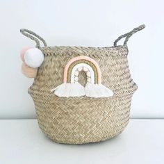 a small basket with a rainbow on the front and a pom - pom in the back