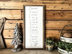 a wooden sign with writing on it next to potted plants and a snowman