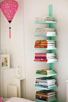 a room with a bed, bookshelf and pink balloons in the air hanging from the ceiling