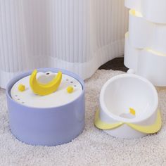 two white and yellow bowls sitting on top of a carpeted floor next to each other