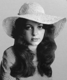 an old photo of a woman wearing a hat