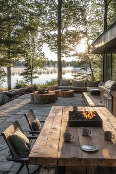 an outdoor fire pit with chairs and tables on the patio next to it is surrounded by trees