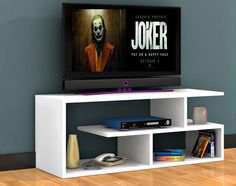 a white entertainment center with a joker movie on the tv