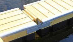 a wooden dock sitting on top of a body of water next to a boat ramp