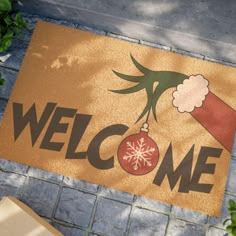 a welcome mat with a christmas ornament hanging from it