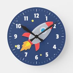 a blue clock with a rocket ship on it's face and numbers in the middle