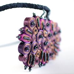 a close up of a purple and black beaded purse