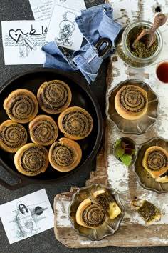 several pastries are sitting on a tray next to some cups and spoons with tea in them