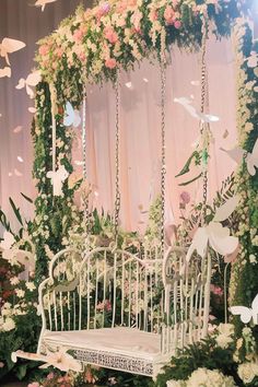 a white bench surrounded by flowers and butterflies