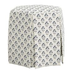 a white and blue ottoman cover with flowers on it