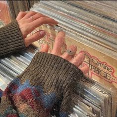 a woman's hand on top of a stack of records