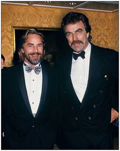 two men in tuxedos posing for a photo