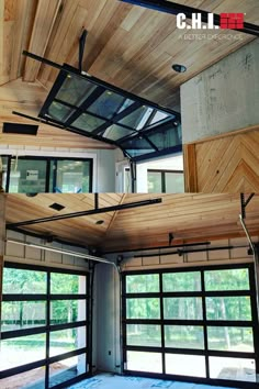 the inside of a garage with wood paneling on the ceiling and glass doors open