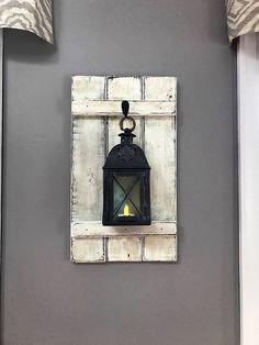 a light that is on the side of a wall next to a lamp holder with a candle in it